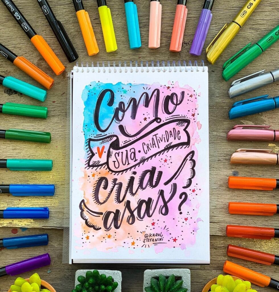 lettering com canetas em volta e com desenho de asas